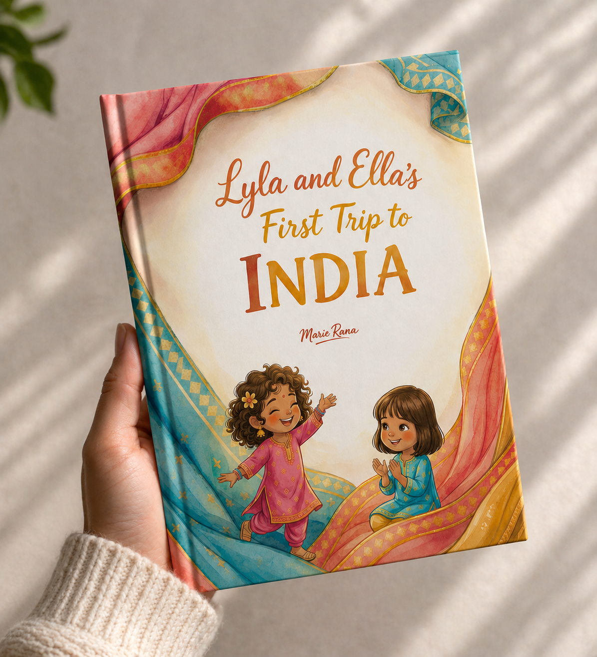 Lyla and Ella's First Trip to India book cover showing the hardcover held up against warm light